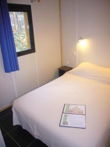 a room with a bed with a sign on it at ULVF Le Domaine de Pelvezy in Saint-Geniès