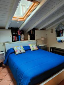 een groot blauw bed met 2 kussens in een kamer bij La mansarda di Ninni in Catania