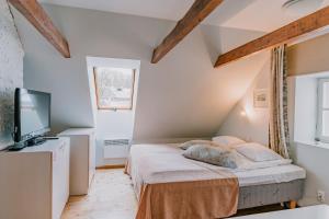 a small bedroom with a bed and a television at Tampere Maja in Tartu