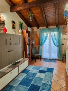 een keuken met blauwe gordijnen, een tafel en een raam bij La mansarda di Ninni in Catania