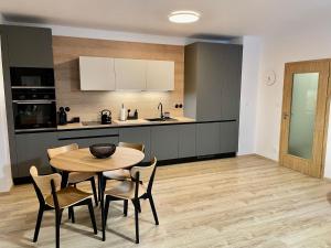 - une cuisine et une salle à manger avec une table et des chaises dans l'établissement Apartmán Hubertus No. 17, à Karlova Studánka