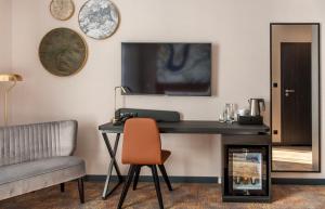 Mercure Bialystok في بياويستوك: غرفة بها مكتب وكرسي ومرآة