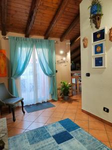 a living room with a blue curtain and a window at La mansarda di Ninni in Catania