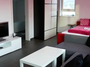 ein Wohnzimmer mit einem Bett, einem Sofa und einem TV in der Unterkunft Ferien in Bad Aibling in Bad Aibling