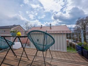 einem grünen Stuhl auf einer Terrasse mit einem Tisch in der Unterkunft Ferien in Bad Aibling in Bad Aibling