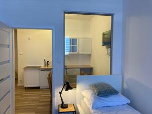 a small room with a bed and a kitchen at Apartament Centrum Szczytno II in Szczytno
