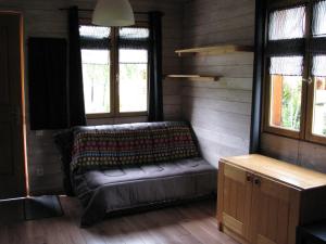 a living room with a couch in a room with windows at Apartment Chalet Bourg d'Oisans in Le Bourg-dʼOisans