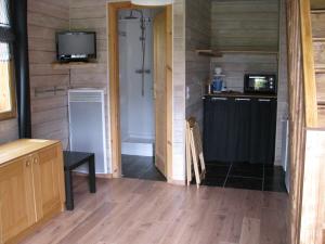 a room with a kitchen and a television in a room at Apartment Chalet Bourg d'Oisans in Le Bourg-dʼOisans