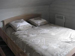 a bed with two pillows on it in a room at Apartment Chalet Bourg d'Oisans in Le Bourg-dʼOisans +2 photos