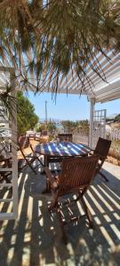 a table and chairs under an umbrella on a patio at Aegean Star Hotel in Karavostasi