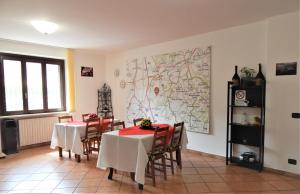 a dining room with two tables and a map on the wall at Amo' le Langhe in Narzole