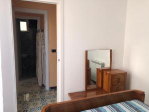 einen Spiegel und eine Kommode in einem Zimmer in der Unterkunft B&B Villa zia Febronia in Patti