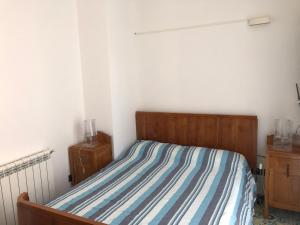 una camera da letto con un letto con un piumone a righe di B&B Villa zia Febronia a Patti