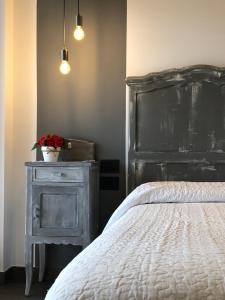 - une chambre avec un lit et une commode avec une plante dans l'établissement Appartamento vista lago Le Terrazze piscina-tennis-parking, à Menaggio