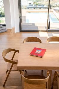 a red book on a wooden table with chairs at Seametry Luxury Living Penthouse in Souda