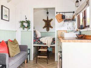 cocina y sala de estar con sofá y cama en Badgers Rest en Tintagel