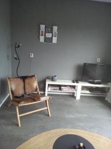 ein Wohnzimmer mit einem Stuhl und einem TV in der Unterkunft 55 Bytling in Terherne