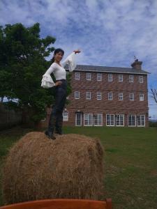 uma mulher em cima de um monte de feno em 墾丁勿忘我城堡莊園 em Hengchun South Gate