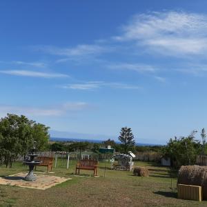 un grupo de bancos en un parque con fardos de heno en 墾丁勿忘我城堡莊園, en Hengchun