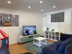 a living room with a couch and a tv at My Portugal for All - Oporto Flat in Vila Nova de Gaia