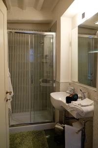 a bathroom with a glass shower and a sink at B&B LA CHIMERA in Arezzo