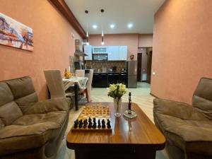 uma sala de estar com um tabuleiro de xadrez sobre uma mesa em Metta Tbilisi Apartment em Tbilisi