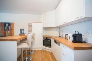 eine Küche mit weißen Schränken und einer hölzernen Arbeitsplatte in der Unterkunft Apartment - Feldstrasse 30-O Winterberg in Winterberg
