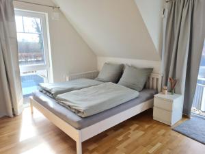 Cama en habitación con ventana grande en Haus Belvedere in Sehlendorf en Blekendorf