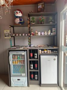 a small refrigerator next to a shelf with drinks at Pousada Angela in Urubici +11 photos