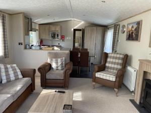 a living room with a couch and chairs and a kitchen at Beautiful 2 bedroom Helmsley Lodge in Northampton