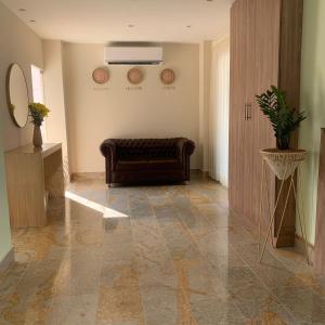 ein Wohnzimmer mit einem Ledersofa und einem Spiegel in der Unterkunft Hotel Calarca Plus in Montería
