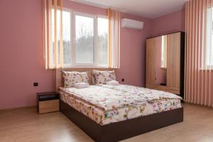 een slaapkamer met een groot bed in een roze kamer bij Апартамент ФЕЯ - топ център, безплатно паркомясто in Gabrovo