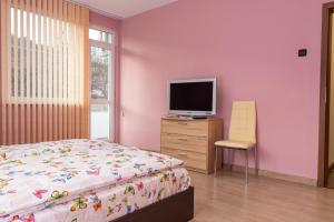 een slaapkamer met een bed en een televisie op een dressoir bij Апартамент ФЕЯ - топ център, безплатно паркомясто in Gabrovo