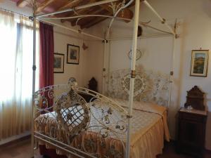 Dormitorio con cama con dosel de metal en una habitación en Az.Agricola Agriturismo La Locanda di LANN, en Fucecchio