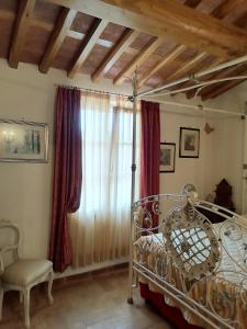 ein Schlafzimmer mit einem Metallbett und einem Fenster in der Unterkunft Az.Agricola Agriturismo La Locanda di LANN in Fucecchio