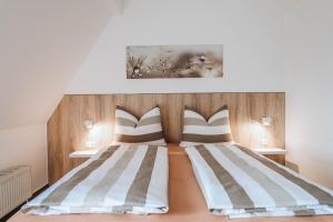 a bedroom with a bed with striped pillows at XXL Ferienhaus Goldberger See - Sauna - 16 Personen in Goldberg