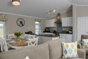ein Wohnzimmer und eine Küche mit einem Tisch und einem Sofa in der Unterkunft Croyde Bay Hotel or Self Catering in Croyde