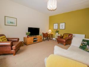 a living room with couches and a flat screen tv at Crow's Nest in Carnforth