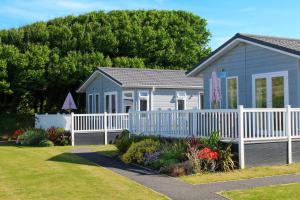 a blue house with a white fence and flowers at Croyde Bay Hotel or Self Catering in Croyde