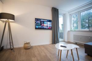 sala de estar con mesa y TV en la pared en Appartement - Weltringpark 2-T Winterberg en Winterberg