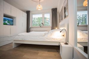 a white bedroom with a bed and two windows at Appartement - Weltringpark 2-T Winterberg in Winterberg