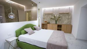 - une chambre avec un grand lit et une tête de lit verte dans l'établissement Marinisa Suite Luxury Room, à Porto Empedocle