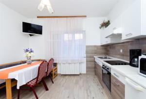 a kitchen and dining room with a table and chairs at Apartments Rezika in Mundanije