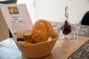 um cesto de pão sentado numa mesa com copos de vinho em Comfort House Mimosa 2 em Palekastron