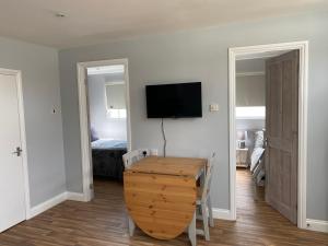 a room with a table and a television on a wall at Shore Thing Holiday Chalet Parkdean K81 in Camber