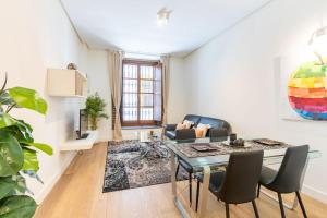 a living room with a table and a couch at Angeles Santa Cruz Deluxe by Valcambre in Seville