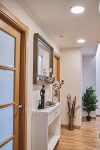 a hallway with a mirror and a shelf with a statue at Pensión A Solaina 3 in O Pedrouzo