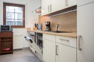 cocina con armarios blancos y encimera en Appartement - Zur Postwiese 15 Neuastenberg 'The Bear House' en Winterberg