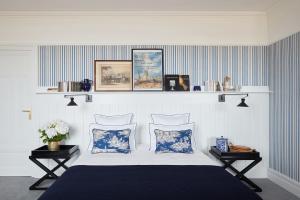 a bedroom with a bed with blue and white stripes at Le Flaubert in Trouville-sur-Mer