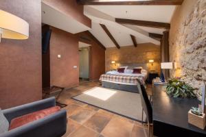 1 dormitorio con 1 cama extragrande y pared de piedra en Castilla Termal Burgo de Osma, en El Burgo de Osma